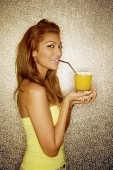 Young woman sipping drink with straw, looking at camera, portrait - Asia Images Group