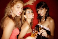 Women looking at camera, holding drinks, smiling - Asia Images Group