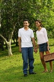 Couple standing in park, holding hands - Asia Images Group