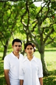 Couple standing in park, looking at camera - Asia Images Group