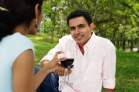 Couple toasting with wine glasses, man looking at camera - Asia Images Group
