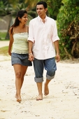Couple walking along beach, holding hands - Asia Images Group