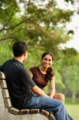 Couple sitting and talking on bench - Asia Images Group