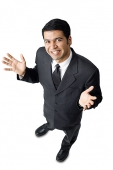 Businessman, hands raised, palms facing up, looking at camera - Asia Images Group