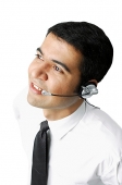Executive wearing headset, looking away - Asia Images Group