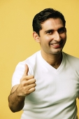 Man smiling at camera, making "thumbs up" sign - Asia Images Group