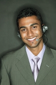 Businessman using headset, looking at camera - Asia Images Group
