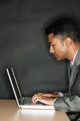Businessman using laptop, side view - Asia Images Group