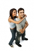 Couple looking at camera, woman hugging man from behind - Asia Images Group