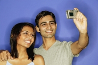 Couple taking a picture of themselves, smiling - Asia Images Group