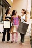 Women carrying shopping bags, standing side by side - Asia Images Group