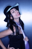 Young woman, wearing hat and tie, smiling, looking at camera - Asia Images Group