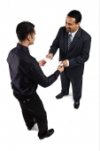 Two businessmen standing and exchanging namecards - Asia Images Group