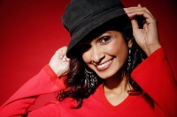 Woman smiling at camera, adjusting hat on head - Asia Images Group
