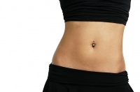 Woman's mid section with belly button ring - Asia Images Group