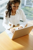 Woman at desk, using laptop - Asia Images Group