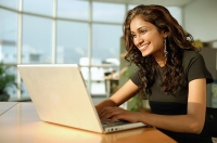 Woman using laptop, smiling - Asia Images Group