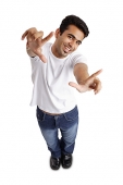 Man smiling at camera, arm outstretched, making hand sign - Asia Images Group