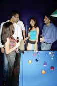 Young adults standing around pool table - Asia Images Group