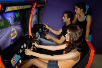 Young adults playing games in amusement arcade - Asia Images Group