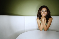 Young woman sitting in booth, smiling at camera - Asia Images Group