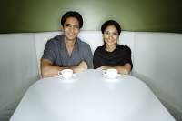 Couple sitting side by side looking at camera - Asia Images Group