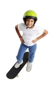 Boy with helmet, standing on skateboard, hand on hip - Asia Images Group