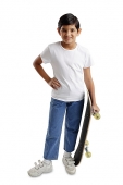 Boy standing, holding skateboard, hand on hip - Asia Images Group