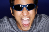 Man in sunglasses, shouting - Asia Images Group