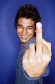 Man smiling at camera, making a hand sign with finger - Asia Images Group