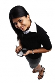 Woman holding PDA, smiling at camera - Asia Images Group