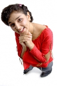 Woman smiling at camera, hands clasped under chin - Asia Images Group