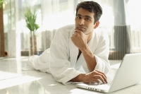 Man in bathrobe, hand on chin, looking at camera - Asia Images Group