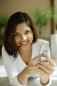Woman smiling at camera, mobile phone - Asia Images Group
