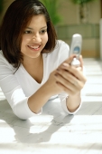 Woman looking at mobile phone, smiling - Asia Images Group