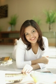 Woman smiling at camera, lying on floor - Asia Images Group
