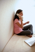 Woman at home, holding credit card, talking on cordless phone - Asia Images Group