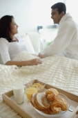 Couple in bedroom, breakfast tray on the bed - Asia Images Group