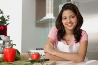 Woman sitting in kitchen, smiling at camera - Asia Images Group