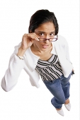 Woman looking up at camera, adjusting glasses, high angle view - Asia Images Group