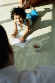 Girl lying on floor, smiling at her father - Asia Images Group