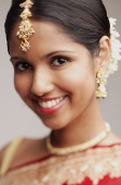 Woman in wearing Indian jewellery, smiling at camera - Asia Images Group