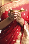 Woman in sari holding oil lamp, cropped image - Asia Images Group