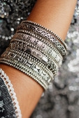 Close-up of woman's arm with silver bangles - Asia Images Group