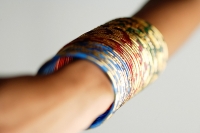 Close-up of woman's arm with colourful bangles - Asia Images Group