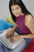Woman sitting on floor with laptop, looking up - Asia Images Group