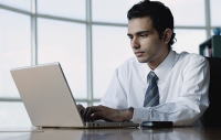 Young businessman using laptop - Asia Images Group
