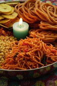 A mixed snack platter with a candle - Asia Images Group