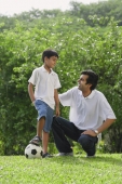 A father and son play soccer together - Asia Images Group