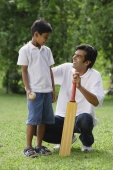 A father and son play cricket together - Asia Images Group
